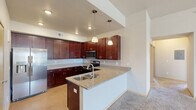 Located at 1755 Moon Meadows Drive in Rapid City, South Dakota, this single-story home offers five bedrooms and two bathrooms within a well-organized floor plan. The kitchen is a standout feature, showcasing rich dark cabinetry, granite countertops, a peninsula with an undermount sink, stainless steel appliances including a refrigerator, electric range, and built-in microwave, plus pendant lighting overhead. The layout transitions smoothly into the living area, which is finished with plush carpeting, a ceiling fan, and access to a private balcony through sliding glass doors, accompanied by a large window that fills the space with natural light and neighborhood views. The five bedrooms are carpeted and feature neutral walls; several include windows with exterior views, and at least one includes a closet with sliding doors and built-in shelving. The bathrooms are finished with dark vanity cabinetry, granite countertops, and a tub-shower combination with tile accents. A dedicated laundry room houses a full-size washer and dryer with overhead wire shelving, adding everyday convenience to this functional and comfortable Rapid City home.