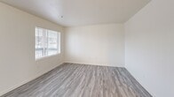 Located at 620 NE Kamiaken St in Pullman, Washington, this two-bedroom apartment offers a well-organized single-level layout with a clean, neutral aesthetic throughout. The unit features light-toned luxury vinyl plank flooring that runs continuously through all rooms, contributing to a bright and cohesive feel.

The kitchen is designed in a U-shaped configuration with ample white cabinetry extending to the ceiling, providing generous storage space. Light green countertops, a built-in electric range, refrigerator, and a peninsula with a breakfast bar connect the kitchen to the adjoining living area, creating an open and functional shared space. Natural light enters through a window fitted with horizontal blinds, offering views of the surrounding neighborhood.

Both bedrooms are well-proportioned, with the primary bedroom offering a comfortable footprint. Each room features windows with blinds that allow for natural light and outdoor views, along with baseboard heating units for year-round comfort. The rooms present clean white walls, providing a neutral canvas adaptable to various furnishing styles.

The overall ambiance of the unit is bright, clean, and practical, making it a functional living space well-suited for those seeking a straightforward, move-in-ready home in Pullman.