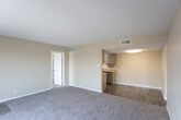Located at 3101 N Midland Dr in Midland, Texas, this single-story unit offers a practical and well-organized floor plan suited for comfortable everyday living. The entry opens into a spacious living area finished with plush wall-to-wall carpeting and warm beige walls, transitioning seamlessly into a kitchen and dining space with durable wood-look flooring. The galley-style kitchen is efficiently laid out with ample cabinetry in a neutral gray-beige tone, light countertops, a stainless steel sink, and a full suite of black appliances including a gas range, microwave, and refrigerator. Textured ceilings are found throughout the unit. Multiple bedrooms feature generous proportions, soft carpeting, large windows with blinds that invite natural light, and access to walk-in closet storage. Two full bathrooms serve the unit, each equipped with a shower-tub combination, vanity with under-sink cabinetry, and wood-look flooring. One bathroom includes additional overhead cabinetry for extra storage. The overall ambiance is clean, neutral, and move-in ready, with a consistent design palette of warm beige tones, white trim, and practical finishes throughout.