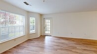 Located in Danvers, MA, this well-appointed one-bedroom, one-bathroom residence is thoughtfully laid out across a single floor. Warm hardwood-style flooring flows consistently throughout, lending a cohesive and clean aesthetic to every room.

The open living area is bright and inviting, benefiting from multiple windows and a glass-panel door that fills the space with natural light and provides direct outdoor access to a private patio. The seamless connection between the living area and the adjacent kitchen creates an efficient, open feel.

The galley-style kitchen is well-equipped, featuring white cabinetry, light countertops with a breakfast bar overhang, and a full suite of appliances including a gas range, refrigerator, and dishwasher. A dedicated laundry area and electrical panel access are conveniently tucked nearby.

The bedroom is a comfortable, well-proportioned retreat with multiple windows offering outdoor views of greenery. It includes a reach-in closet with dual hanging rods and shelving, providing ample storage.

The bathroom features a full tub-shower combination with white tile surround, complemented by hardwood-style flooring that continues from the rest of the unit. Clean white walls and neutral tones throughout the residence create a bright, move-in-ready environment.