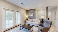 Located at 220 Marshall Rd in Monaca, PA, this well-appointed one-bedroom, two-bathroom residence offers a thoughtfully designed single-floor layout with modern finishes throughout. The open-concept living room features light wood-look flooring, recessed lighting, and a neutral color palette accented by a bold gray feature wall. French doors flood the space with natural light and provide direct access to an outdoor area. The kitchen is a standout, boasting rich dark cabinetry, granite countertops, a large center island with pendant lighting, and a full suite of stainless steel appliances including a range, microwave, refrigerator, and dishwasher. The spacious primary bedroom is carpeted for comfort, includes a ceiling fan, and is served by two windows offering natural light. It connects to a full bathroom and a generously sized walk-in closet with wire shelving. A second full bathroom features wood-look luxury vinyl plank flooring and a tub-shower combination. The neutral tones and clean finishes found throughout the home create a cohesive and modern ambiance, making this residence a practical and attractive place to call home.