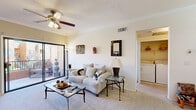 This thoughtfully designed single-floor residence offers a comfortable and functional layout across five distinct areas, including a combined kitchen and living room, one bedroom, one bathroom, a hallway, and a closet. The open-concept living room is finished with plush carpeting and features a ceiling fan with light fixture, crown molding, and large sliding glass doors that open onto a private balcony, filling the space with natural light and providing outdoor views. The kitchen is equipped with stainless steel appliances, including a gas range, microwave, and refrigerator, complemented by contemporary light wood cabinetry, dark granite countertops, hexagonal tile flooring, and a breakfast bar peninsula. Recessed lighting adds a polished touch to the kitchen and dining area. The bedroom is a well-proportioned retreat with soft carpeting, a large window overlooking a natural outdoor setting, and convenient access to the hallway. The bathroom features a full soaking tub and shower combination with white tile surround, hexagonal marble-style floor tiles, a dark granite vanity top, and a wide mirror. An in-unit laundry area with washer and dryer hookups is also accessible from the main living space, adding everyday convenience to this well-rounded residence.