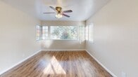 Located at 6655 N Fresno St in Fresno, CA, this well-appointed single-floor residence offers 1 bedroom and 2 full bathrooms within a thoughtfully designed layout. The open-concept living, dining, and kitchen area forms the heart of the home, finished with warm wood-look flooring and bathed in natural light from multiple windows and a sliding glass door. Dual ceiling fans keep the space comfortable year-round. The kitchen features white cabinetry, a skylight, a peninsula with light stone-look countertops, and black appliances including a refrigerator, range, and dishwasher — offering both style and function. The peninsula provides a natural transition into the dining and living areas, creating a cohesive, social environment. Sliding glass doors open directly onto a private balcony with a wood-railed surround and peaceful views of mature trees and the surrounding neighborhood. The bedroom is carpeted for comfort and receives natural light through a window with blinds, complemented by a dedicated closet. Both bathrooms are clean and bright, one featuring a tub/shower combo with wood-look flooring and the other a light stone vanity with mirrored cabinetry. Additional conveniences include a dedicated laundry area and utility spaces.