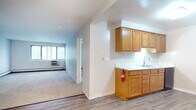 This upgraded 1-bedroom, 1-bathroom unit is thoughtfully laid out across a single floor, offering a comfortable and functional living environment. The kitchen is positioned at the entry and features warm oak cabinetry with ample upper and lower storage, light countertops, a double-basin sink, and black appliances including a gas range. Durable wood-look vinyl plank flooring runs throughout the kitchen and entry areas, providing both style and easy maintenance.

The living area is generously sized, finished with wall-to-wall carpeting, and benefits from natural light through a large window. A ceiling fan adds to the comfort of the space. The open layout connects the kitchen to the living area seamlessly, creating an efficient flow throughout the unit.

The bedroom is carpeted and features a roomy closet with a built-in shelf and hanging rod, providing practical storage. Neutral wall tones throughout give the space a clean, move-in-ready appearance.

The bathroom has been upgraded and includes a full tub-shower combination with white tile surround, a grey vanity with a white countertop, and wood-look vinyl plank flooring that ties the updated aesthetic together cohesively. This unit combines functional design with tasteful upgrades for comfortable everyday living.