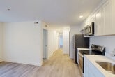 This 4-bedroom, 2-bathroom residence at 315 Anacostia Rd SE in Washington, DC offers a thoughtfully arranged single-floor layout with a clean, modern aesthetic. The open-concept living, dining, and kitchen area serves as the heart of the home, featuring light wood-look flooring, recessed lighting, and crisp white walls that create a bright and welcoming atmosphere. The kitchen is well-appointed with white shaker-style cabinetry, white countertops, and a full suite of stainless steel appliances including a refrigerator, gas range, over-the-range microwave, and dishwasher. A central hallway connects the living spaces to the four bedrooms, each finished with the same light flooring and neutral white walls. The bedrooms benefit from natural light through windows fitted with blinds, and several rooms include closet space — with six closets total throughout the unit. Both bathrooms are finished in a clean, contemporary style; one features a full soaking tub with marble-look tile surround, a white vanity, and wood-look tile flooring. The consistent use of light tones and modern materials throughout gives the entire residence a cohesive, fresh feel well-suited to everyday living.