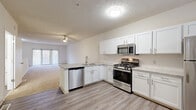 Located at 2252 Par Ln in Willoughby Hills, Ohio, this two-story, 2-bedroom, 3-bathroom home offers a well-organized layout spread across two floors. The main level features an open-concept kitchen and living area with durable wood-look flooring. The kitchen is equipped with crisp white shaker cabinetry, granite-style countertops, a peninsula with an integrated sink, and a full suite of stainless steel appliances including a gas range, built-in microwave, and dishwasher. The adjacent living and dining areas are finished with neutral carpet and ceiling fans, and a sliding glass door opens to a private balcony with views of surrounding trees. The upper level houses both bedrooms, including a spacious primary bedroom with a ceiling fan and its own bathroom featuring a soaking tub with a curved shower rod. Additional bathrooms are clean and functional, with wood-look flooring and built-in cabinetry. The upper floor also features multiple closets, providing generous storage throughout. A dedicated laundry area and hallway complete the layout. Neutral tones, textured ceilings, and consistent finishes give the home a cohesive, move-in-ready feel.