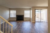 Located at 10057 Big Pine Dr in Rancho Cucamonga, CA, this single-floor residence offers a thoughtfully designed layout with a blend of modern updates and comfortable living spaces. The living room serves as a central gathering area, anchored by a sleek fireplace with a dark surround and rich wood-style flooring. A large sliding glass door opens to a private balcony, filling the space with natural light and offering views of the surrounding neighborhood and mature trees. The kitchen has been updated with crisp white shaker cabinetry, dark countertops, stainless steel appliances including a gas range, microwave, dishwasher, and refrigerator, as well as a tray ceiling with recessed lighting that adds a refined architectural touch. Wood-look flooring carries through the kitchen, complementing the clean, contemporary aesthetic. The bedrooms are carpeted for comfort, each featuring windows with blinds that invite natural light. The primary bedroom includes a sliding door leading to its own outdoor access with tree-lined views. Two bathrooms are finished with white cabinetry, dark countertops, and wood-style flooring, one featuring a shower-tub combination. Neutral wall tones and textured ceilings are consistent throughout, creating a cohesive and move-in-ready atmosphere.