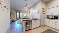Located at 770 S Harbor Blvd in Fullerton, CA, this two-bedroom, one-bathroom residence offers a thoughtfully designed single-level layout with modern finishes and an efficient use of space. The open-concept kitchen and living area serves as the heart of the home, featuring a peninsula with a dark quartz countertop and bar seating, white shaker cabinetry, a subway tile backsplash, and a full suite of stainless steel appliances including a French door refrigerator, dishwasher, and microwave. Light wood-style flooring flows throughout, enhancing the bright, airy atmosphere. The living room offers access to a private balcony through glass doors, allowing natural light to fill the space and providing outdoor views. The two bedrooms are comfortably sized, with the primary bedroom featuring a window with outdoor views and ample closet space. The shared bathroom is clean and well-appointed, with tile flooring, a combined tub and shower, and a white vanity with a neutral countertop. A hallway connects the main living areas to the bedrooms, providing a logical and functional flow. Throughout the residence, neutral wall tones and consistent flooring choices create a cohesive, contemporary aesthetic well-suited for modern living in the heart of Fullerton.