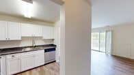 This two-bedroom, one-bathroom residence at Silver Lake Blvd in Alexandria, Virginia, offers a well-organized single-floor layout designed for comfortable living. The kitchen is a standout feature, equipped with crisp white shaker cabinetry, dark stone countertops, stainless steel appliances including a refrigerator, range, and dishwasher, and durable wood-style flooring that extends into the adjoining areas. The living room is bright and welcoming, benefiting from large sliding glass doors that open to a private balcony, allowing generous natural light to fill the space. An elegant chandelier adds character to the dining area, which flows naturally from the kitchen. The primary bedroom is a comfortable retreat with plush carpeting, a walk-in closet, and an additional closet for extra storage. The second bedroom also features wood-style flooring and direct balcony access. The bathroom includes a full tub and shower combination with classic white tile surround and chrome grab bar fixtures. A dedicated hallway and closet provide additional storage and organization throughout. The neutral color palette and clean finishes create a bright, move-in-ready atmosphere throughout the entire residence.