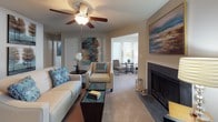Located at 1916 Sam Rittenberg Blvd in Charleston, SC, this single-floor residence offers a thoughtfully designed layout with comfortable living spaces and cohesive finishes throughout. The kitchen is well-equipped with dark espresso cabinetry, granite-style countertops, black appliances including a refrigerator, dishwasher, and range, and a peninsula with bar seating — ideal for casual dining. Wood-style flooring runs through the kitchen and transitions seamlessly into the adjacent dining area, which features a pendant-lit ceiling and space for a round dining table. The living room is a central gathering space highlighted by a fireplace, ceiling fan, and neutral carpet. It opens into a bright sunroom or sitting area filled with natural light from large windows, providing a versatile secondary lounge space. The bedrooms are carpeted and generously sized, each featuring ceiling fans, windows with natural light, and ample room for full furniture arrangements. The bathroom includes a dark-vanity with granite-style countertop, a tub-shower combination, and wood-style flooring. Throughout the residence, a soft blue and beige color palette creates a calm, cohesive ambiance, making this a comfortable and functional home in the heart of Charleston.