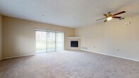 This single-floor residence on Cedar Trail in Willoughby Hills, Ohio offers a thoughtfully arranged layout with neutral tones and carpet flooring throughout the main living and bedroom areas. The expansive living room is a standout feature, anchored by a corner fireplace with a clean white mantle and served by a ceiling fan overhead. Large sliding glass doors flood the space with natural light and provide direct access to the outdoors, while an additional window enhances the bright, open atmosphere.

The kitchen is well-equipped with white shaker-style cabinetry, dark countertops, hardwood flooring, and a full suite of stainless steel appliances including a refrigerator, range, microwave, and dishwasher. Track lighting and a window above the sink add both function and brightness to the space.

The bedrooms are generously sized with plush carpeting, ceiling fans, and ample natural light from windows overlooking greenery. At least one bedroom includes a walk-in closet with built-in shelving. The bathroom features tile flooring, a soaking tub with shower, a white vanity, and clean, neutral finishes throughout. The overall ambiance is calm and move-in ready.