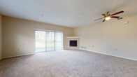 This single-floor residence on Cedar Trail in Willoughby Hills, Ohio offers a thoughtfully arranged layout with neutral tones and carpet flooring throughout the main living and bedroom areas. The expansive living room is a standout feature, anchored by a corner fireplace with a clean white mantle and served by a ceiling fan overhead. Large sliding glass doors flood the space with natural light and provide direct access to the outdoors, while an additional window enhances the bright, open atmosphere.

The kitchen is well-equipped with white shaker-style cabinetry, dark countertops, hardwood flooring, and a full suite of stainless steel appliances including a refrigerator, range, microwave, and dishwasher. Track lighting and a window above the sink add both function and brightness to the space.

The bedrooms are generously sized with plush carpeting, ceiling fans, and ample natural light from windows overlooking greenery. At least one bedroom includes a walk-in closet with built-in shelving. The bathroom features tile flooring, a soaking tub with shower, a white vanity, and clean, neutral finishes throughout. The overall ambiance is calm and move-in ready.