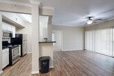 Located at 5045 Crenshaw Rd in Pasadena, TX, this single-story, 3-bedroom, 2-bathroom home offers a well-designed layout that maximizes functionality and comfort. The open-concept living and kitchen area serves as the heart of the home, featuring durable wood-look flooring, crown molding, and a ceiling fan. The kitchen is defined by a dark granite-topped breakfast bar, white cabinetry, stainless steel and black appliances, and a skylight that fills the space with natural light. A sliding glass door in the living area opens to the outdoors, fitted with vertical blinds for privacy. The three bedrooms are carpeted and each equipped with ceiling fans. The primary bedroom offers a walk-in closet, while a secondary bedroom features built-in shelving, adding practical storage. The two bathrooms include wood-look flooring, white cabinetry, and dark granite countertops. A dedicated laundry room houses a full-size washer and dryer alongside wire shelving and a water heater. A connecting hallway ties the rooms together efficiently. Neutral, warm-toned walls throughout create a cohesive and inviting atmosphere across the entire home.