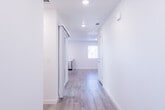 This well-appointed two-story home showcases a clean, modern aesthetic defined by crisp white walls, light wood-style flooring, and recessed lighting throughout. The kitchen serves as a functional centerpiece, featuring white shaker-style cabinetry, bright quartz countertops, a central island, and a full suite of stainless steel appliances including a refrigerator, range, microwave, and dishwasher. A undermount sink is positioned beneath a window, allowing natural light to fill the space.

The living areas are generously proportioned, with multiple windows dressed in white blinds that invite ample natural light and offer views of surrounding greenery. The open layout and neutral palette create a versatile and welcoming atmosphere throughout.

The bathrooms are thoughtfully designed: a half bath on one level features a pedestal sink, round mirror, and a natural light window, while the full bathroom includes a wide vanity with dual sinks, abundant drawer storage, and a separate tub/shower combination. Bedrooms are bright and well-sized, with wide windows and dedicated closet space featuring full-width hanging rods. The home's consistent use of light tones and modern fixtures contributes to a cohesive, move-in-ready environment across both floors.