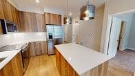 Located at 400 W Swedesford Road in Berwyn, PA, this well-appointed one-bedroom, one-bathroom residence offers a thoughtfully designed single-floor layout. The open-concept kitchen and living area serves as the heart of the home, featuring warm wood-toned cabinetry extending to the ceiling, crisp white quartz countertops, a large center island, stainless steel appliances including a French door refrigerator and range, and stylish pendant lighting. Light hardwood flooring flows throughout the main living areas, enhancing the bright and airy ambiance. The living space is generously lit by multiple windows with clean white blinds, framing views of the surrounding greenery. The bedroom is a comfortable retreat finished with plush carpeting and large windows that invite abundant natural light and outdoor views. A dedicated closet with built-in shelving provides ample storage. The bathroom is finished with modern tile flooring, a wood-grain vanity with a white countertop, an illuminated mirror, and a glass-enclosed walk-in shower with white subway tile surround. Neutral wall tones throughout the residence create a calm, cohesive aesthetic, making this Berwyn home a polished and functional living space.