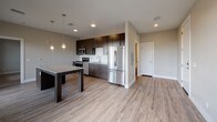 Located on Republic Drive in Colorado Springs, Colorado, this single-floor unit showcases a clean, contemporary design throughout. The open-concept kitchen and living area serves as the heart of the space, finished with light wood-look luxury vinyl plank flooring that extends seamlessly across the common areas. The kitchen is well-equipped with dark espresso cabinetry, granite countertops, a white subway tile backsplash, and a full suite of stainless steel appliances, including a French door refrigerator, electric range, over-the-range microwave, and dishwasher. A granite-topped island with pendant lighting above provides additional prep and dining space.

The bedroom features plush carpeting, a ceiling fan, and a window that admits natural light and exterior views. A walk-in closet with wrap-around hanging rods and shelving offers generous storage. The bathroom continues the unit's consistent design language with granite countertops, dark wood cabinetry, brushed gold fixtures, an undermount sink, and a full tub-shower combination. Recessed lighting and neutral wall tones throughout contribute to a bright, cohesive ambiance.