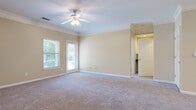 Located at 325 Spears Creek Church Rd in Columbia, SC, this well-appointed single-floor residence offers two bedrooms and two bathrooms within a thoughtfully designed layout. The kitchen is a functional centerpiece, featuring light maple cabinetry, dark granite-style countertops, tile flooring, a breakfast bar peninsula, track lighting, and black appliances including a dishwasher, range, microwave, and refrigerator. Crown molding accents the kitchen and adjoining areas, adding a refined architectural touch throughout. The spacious primary bedroom is highlighted by soft carpeting, a ceiling fan with light fixture, crown molding, and natural light from multiple windows with outdoor views. It connects to a private bathroom and a walk-in closet with built-in shelving. The second bedroom also features plush carpet, a window with natural light, and access to a closet. The second bathroom includes a tiled tub-shower combination, tile flooring, and vanity. Neutral, warm beige tones carry throughout the home, creating a cohesive and welcoming ambiance. A connecting hallway links the living areas to the bedrooms, providing a practical and organized flow across the entire single-level floor plan.