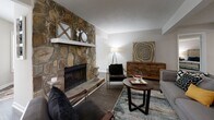 Located in Sandy Springs, GA, this well-appointed 2-bedroom, 5-bathroom single-story home offers a thoughtfully designed layout with a seamless flow between living spaces. The living room serves as the heart of the home, anchored by a striking floor-to-ceiling stacked stone fireplace that creates a warm, inviting focal point. Rich hardwood-style flooring runs through the main living areas, complementing the neutral palette throughout.

The kitchen is efficiently designed with white cabinetry, light stone countertops, stainless steel appliances, and a breakfast bar that connects to the adjacent dining area. The dining room features wainscoting, pendant lighting, and hardwood-style flooring, creating a refined yet comfortable space for entertaining.

The generously sized primary bedroom is carpeted for comfort and includes natural light from large windows, direct access to additional rooms, and ample closet space. The second bedroom is equally well-proportioned with plush carpet flooring. Five bathrooms ensure exceptional convenience for residents and guests alike.

A dedicated laundry room houses a full-size washer and dryer with overhead shelving. Two closets provide additional storage throughout the home, rounding out a practical and comfortable living experience in a desirable Sandy Springs location.
