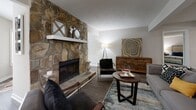 Located in Sandy Springs, GA, this well-appointed 2-bedroom, 5-bathroom single-story home offers a thoughtfully designed layout with a seamless flow between living spaces. The living room serves as the heart of the home, anchored by a striking floor-to-ceiling stacked stone fireplace that creates a warm, inviting focal point. Rich hardwood-style flooring runs through the main living areas, complementing the neutral palette throughout.

The kitchen is efficiently designed with white cabinetry, light stone countertops, stainless steel appliances, and a breakfast bar that connects to the adjacent dining area. The dining room features wainscoting, pendant lighting, and hardwood-style flooring, creating a refined yet comfortable space for entertaining.

The generously sized primary bedroom is carpeted for comfort and includes natural light from large windows, direct access to additional rooms, and ample closet space. The second bedroom is equally well-proportioned with plush carpet flooring. Five bathrooms ensure exceptional convenience for residents and guests alike.

A dedicated laundry room houses a full-size washer and dryer with overhead shelving. Two closets provide additional storage throughout the home, rounding out a practical and comfortable living experience in a desirable Sandy Springs location.