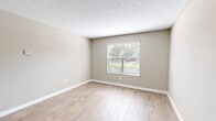 Located along the scenic SR-A1A corridor in Jacksonville, Florida, this single-floor residence offers a practical and comfortable layout across two bedrooms and two bathrooms. The kitchen is a standout feature, equipped with white shaker-style cabinetry, light stone countertops, a subway tile backsplash, and black appliances including a range, microwave, and dishwasher. Wood-look flooring runs throughout the kitchen and extends into the hallway, creating a cohesive and easy-to-maintain finish. Both bedrooms are carpeted and feature neutral taupe walls, textured ceilings, and windows with blinds that allow natural light to fill each room. The primary bedroom benefits from a dedicated walk-in closet outfitted with wire shelving and hanging rods for generous storage. Each bathroom mirrors the home's clean aesthetic with white cabinetry, stone-topped vanities, wood-look tile flooring, and full tub-shower combinations with tiled surrounds. A dedicated laundry room houses a side-by-side washer and dryer with overhead shelving for added convenience. The overall ambiance is clean, neutral, and move-in ready, making this residence a well-rounded home along Florida's Atlantic coast.
