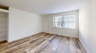 Located at 2265 Perry Blvd NW in Atlanta, GA, this single-story, 3-bedroom, 1-bathroom home offers a practical and well-appointed layout. Wood-look plank flooring runs throughout the main living areas, giving the space a clean, contemporary feel. The living room is bright and open, with neutral white walls, textured ceilings, and natural light filtering in through windows near the entry door. A connected hallway guides residents through the home's efficiently designed floor plan. The combined dining and kitchen area is a functional highlight, featuring white shaker-style cabinetry, granite countertops, a subway tile backsplash, and a full suite of black appliances including a refrigerator, dishwasher, and range with overhead ventilation. A stacked washer and dryer unit is also conveniently located in the kitchen area. All three bedrooms are carpeted for comfort and are fitted with ceiling fans. The primary bedroom benefits from dual windows that allow ample natural light. The additional bedrooms are similarly bright with window access. The bathroom is clean and minimal, featuring a full soaking tub and shower combination with white tile surround and a window for natural ventilation. Two closets provide supplementary storage throughout the home.