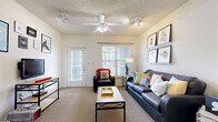 This well-appointed single-story residence offers three bedrooms and four bathrooms across a thoughtfully designed floor plan. The inviting living room serves as the heart of the home, featuring carpet flooring, a ceiling fan with light fixture, track lighting, and large windows dressed with blinds that fill the space with natural light. A glass-paned exterior door provides additional brightness and outdoor access. The kitchen is equipped with warm wood cabinetry, white appliances including a refrigerator, range, and built-in microwave, complemented by tile flooring and a pantry for extra storage. Conveniently adjacent to the kitchen is a dedicated in-unit laundry area with washer and dryer hookups. Each bedroom offers carpeted flooring, windows, and closet space, with at least one bedroom featuring a built-in desk with shelving — ideal for a home office or study area. The four bathrooms are each finished with tiled flooring and full tub-shower combinations. Two hallways connect the rooms, ensuring smooth circulation throughout. With four closets distributed across the unit, storage is plentiful. The neutral color palette and consistent finishes throughout create a cohesive and functional living environment.