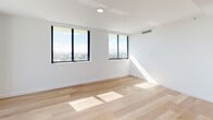 Located at 303 South Federal Highway in Hollywood, FL, this well-appointed 3-bedroom, 2-bathroom residence offers a bright and modern living experience across a single floor. The interior is characterized by clean white walls, light-toned hardwood flooring, and recessed lighting throughout, creating a cohesive and contemporary aesthetic.

The open-concept dining and kitchen area is a functional highlight, featuring flat-front cabinetry extending to the ceiling, stainless steel appliances including a refrigerator, range, and over-the-range microwave, white quartz countertops, and a kitchen island. A window above the sink allows natural light to fill the space.

The three bedrooms are generously sized, with the primary bedroom offering expansive floor-to-ceiling windows framing sweeping city and treetop views. Additional bedrooms also benefit from large windows and abundant natural light. Closet space is plentiful, with built-in shelving and drawers featured in several of the four closets throughout the residence.

Both bathrooms are finished in crisp white, with one featuring a combined tub and shower, a wide vanity with an undermount sink, and large mirror. A dedicated laundry area and a balcony round out the amenities, while two hallways connect the living spaces efficiently.