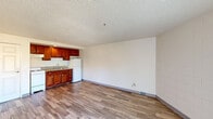 Located in Desert Hot Springs, California, this one-bedroom, one-bathroom unit offers a practical and well-organized layout across a single floor. The open-plan living, dining, and kitchen area forms the heart of the space, featuring wood-look laminate flooring, painted cinder block walls, and a textured ceiling throughout. The kitchen is outfitted with rich cherry-toned cabinetry, a granite-look countertop, a sink, and a full-size refrigerator. The living and dining area is bright and open, benefiting from natural light and direct access to not one but two balconies through sliding glass doors, offering views of the surrounding Desert Hot Springs landscape. Each balcony access point is equipped with a wall-mounted HVAC unit for individual climate control. The spacious bedroom features the same wood-look flooring, a sliding door to a balcony, and an adjacent closet with shelving. The bathroom includes a full tub and shower combination with built-in corner shelving, a grab bar, and clean white surrounds. A dedicated closet provides additional storage. This unit delivers a straightforward, functional living environment suited to the desert surroundings of the Coachella Valley.