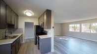 Located at 6419 Vanalden Ave in the Reseda neighborhood of Los Angeles, this single-story unit offers a thoughtfully updated interior with a neutral color palette and a mix of hard-surface and carpeted flooring throughout.

The kitchen is a functional highlight of the space, featuring dark cabinetry, a subway tile backsplash, light quartz-style countertops, and stainless steel appliances including a refrigerator and gas range. A window above the sink allows natural light to filter in, with views of the surrounding exterior. The kitchen flows openly toward the living area, which is generously proportioned and finished with light-toned wood-look flooring. Large windows along one wall bring in ample natural light and provide outdoor views, contributing to an airy, open atmosphere. A ceiling fan is also present in the living space.

The bedrooms are carpeted and finished with the same soft gray tones seen throughout the unit. Closet space is well-represented, with at least one room featuring sliding-door closets with built-in shelving and another offering a spacious walk-in closet with a full rod and shelf system.

The bathroom includes a gray vanity with a quartz-style countertop, an integrated sink, a mirrored medicine cabinet, and a tub-shower combination, all finished cleanly in light, neutral tones.