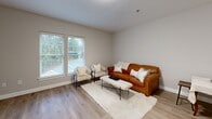 Located at 66 Hawthorne Dr in Bedford, NH, this one-bedroom, one-bathroom residence at Waumbek offers a thoughtfully designed single-floor layout that maximizes both comfort and functionality. The living room features light hardwood-style flooring, neutral wall tones, and multiple windows fitted with blinds that allow abundant natural light while offering views of the surrounding greenery. The open feel of the living area flows naturally toward a dining space, making it ideal for everyday living. The kitchen is outfitted with crisp white shaker cabinetry, granite countertops, a stainless steel sink, and modern hardware, providing a clean and practical cooking environment with ample storage. The bedroom is carpeted for warmth and comfort, featuring dual windows that invite natural light and a spacious closet with classic double doors. The bathroom is finished with tile flooring, a granite-topped vanity with a undermount sink, and a walk-in shower equipped with grab bars for accessibility, all presented in a neutral, spa-like palette. Throughout the residence, consistent neutral tones, clean lines, and quality finishes create a cohesive and inviting atmosphere well-suited to modern living in Bedford, NH.