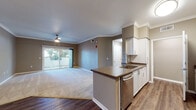 Located at 1912 W Texas St in Fairfield, California, this single-floor residence offers a well-designed open-concept layout finished with warm neutral tones and crown molding throughout. The living area is generously sized, featuring plush carpeting, a ceiling fan, and a sliding glass door that opens to a private outdoor patio, allowing natural light to fill the space. Crown molding adds a polished architectural detail along the ceilings.

The kitchen is thoughtfully appointed with white cabinetry, dark countertops, a peninsula with an undermount sink, and a full suite of stainless steel appliances including a dishwasher, refrigerator, and range. Wood-look flooring runs through the kitchen and entry areas, providing a clean contrast to the carpeted living and bedroom spaces.

The primary bedroom is well-proportioned with carpeted floors and a built-in vanity area, while an additional bedroom offers natural light through a window with blinds. Two bathrooms serve the unit — one featuring a soaking tub and shower combination with tile surround, white cabinetry, and wood-look flooring, and a second with a tub/shower combo and hardwood-style floors. The overall layout is practical and comfortable, suited for everyday living.
