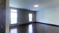 Located at 205 S High St in the heart of downtown Columbus, Ohio, this two-floor space offers a clean, modern aesthetic with thoughtful design details throughout. The interior is characterized by rich, dark hardwood flooring that adds warmth and elegance to each room, complemented by neutral gray and white wall tones that create a bright, versatile backdrop. Multiple windows allow generous amounts of natural light to fill the space, enhancing the open and airy atmosphere. Flush-mounted ceiling lighting provides consistent illumination, while floor vents indicate a well-integrated climate control system. The bold, dark baseboards provide a sharp contrast against the lighter walls, adding a refined architectural touch. Spanning two floors, the layout offers a functional separation of spaces suited for a variety of uses. The overall ambiance is contemporary and polished, with a minimalist sensibility that allows the quality of the finishes — particularly the gleaming hardwood floors — to take center stage. The South High Street address places the property in close proximity to Columbus's vibrant downtown core, with easy access to dining, business, and cultural amenities.