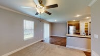 Located at 15520 Trailside Dr in Parkville, MO, this two-story home offers a well-designed layout with modern finishes throughout. The main level features an open-concept living and dining area with warm hardwood-style flooring, crown molding, a ceiling fan, and a sliding glass door that invites natural light. The kitchen is thoughtfully appointed with dark wood cabinetry, granite countertops, stainless steel appliances including a gas range, microwave, and refrigerator, plus a peninsula with a sink that overlooks the living space. A pantry provides additional storage convenience. A full bathroom on this level features hardwood-style flooring, a tub-shower combo, and a granite-topped vanity. Upstairs, the primary bedroom is generously sized with plush carpeting, crown molding, a ceiling fan, and a walk-in closet. Its en-suite bathroom includes a double-sink granite vanity, dark wood cabinetry, and a glass-enclosed shower. Additional bedrooms are carpeted and equipped with ceiling fans and natural light from windows. The staircase connects both levels seamlessly, contributing to the home's functional and cohesive design.