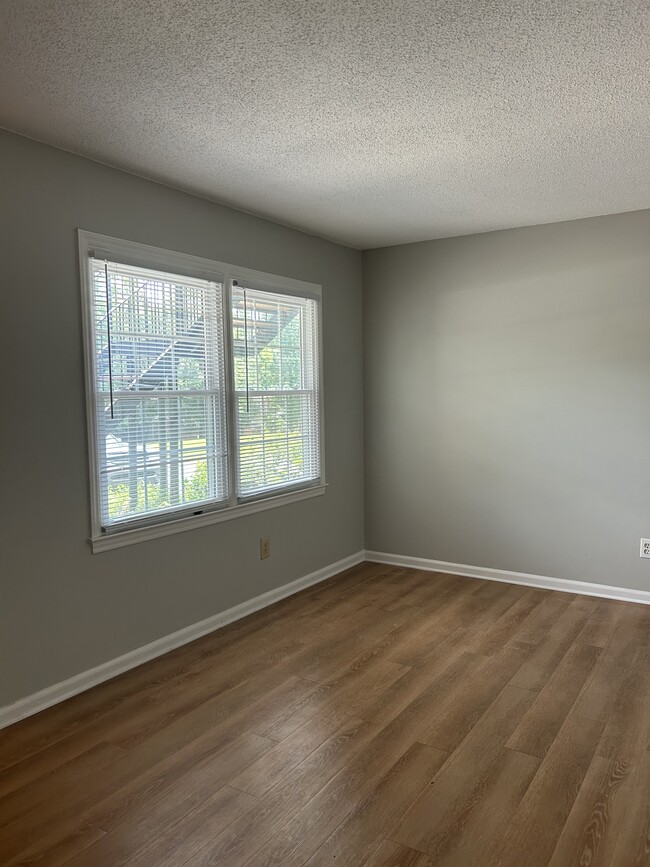 Spacious living room with luxury vinyl plank flooring and fresh paint - 208 Northpoint Ave Unit F