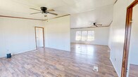 Located at 51000 County Road 512 in Sidon, Mississippi, this single-story home offers four bedrooms, one bathroom, and a combined kitchen and living area across a generously sized floor plan. Wood-look laminate flooring runs throughout the entire home, providing a consistent and cohesive look from room to room.

The combined kitchen and living area anchors the home, with the kitchen featuring white upper and lower cabinetry, a double-basin sink, a range with overhead ventilation, and a refrigerator. Natural light filters in through a window with blinds, brightening the open adjoining living space.

The primary bedroom is notably spacious, equipped with a ceiling fan and light fixture, and benefits from two windows that draw in outdoor views of the surrounding greenery. The remaining three bedrooms are well-sized, each with windows that frame views of the lush yard outside, and several include ceiling fans for added comfort. Two closet doors are visible in one of the bedrooms, offering practical storage.

A hallway connects the bedroom wing to the rest of the home. The bathroom includes a tub-shower combination and toilet. Crown molding details are present in several rooms, adding a subtle decorative touch. The layout is straightforward and functional, making efficient use of the available space throughout.