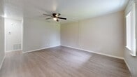 Located at 3560 49th Ave N in Saint Petersburg, FL, this 650-square-foot single-floor unit offers a practical and well-appointed layout across two bedrooms and a combined kitchen and living area. The kitchen is equipped with white cabinetry, granite-style countertops, a white subway tile backsplash, and black appliances including a refrigerator, electric range, and over-the-range microwave. An elegant chandelier accents the kitchen, while light wood-look vinyl flooring extends throughout the kitchen and living areas, creating a clean and cohesive aesthetic. The living room is a well-sized open space featuring a ceiling fan with light and neutral-toned walls that complement the flooring. Both bedrooms are carpeted and include ceiling fans and closets — the primary bedroom at 140 square feet features a reach-in closet with a hanging rod, while the second bedroom offers a sliding-door closet and a window with vertical blinds that allow natural light to filter in. The unit's neutral color palette, consistent finishes, and functional design provide a comfortable and move-in-ready living environment suitable for a variety of residents.
