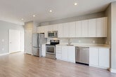 Located at 2255 Wisconsin Ave NW in Washington, DC's vibrant Georgetown neighborhood, this modern 2-bedroom, 3-bathroom residence offers a thoughtfully designed single-floor layout. The open-concept living area seamlessly combines the kitchen, dining, and living spaces, creating a bright and functional hub for everyday living. Light wood-tone flooring flows throughout the main area, complemented by recessed lighting and large sliding glass doors that welcome abundant natural light.

The contemporary kitchen is a standout feature, outfitted with sleek, high-gloss white cabinetry extending to the ceiling for generous storage, stainless steel appliances including a refrigerator, range, microwave, and dishwasher, and clean white countertops. The living area opens to a sliding glass door with outdoor views.

Both bedrooms are carpeted for comfort, with the primary bedroom offering a cozy, well-proportioned retreat. Three full bathrooms each feature tiled tub-shower combinations with chrome fixtures and light tile flooring, providing ample convenience. Three closets and an in-unit laundry room round out the practical amenities, making this a well-appointed residence in one of DC's most sought-after neighborhoods.