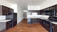 This 400 square foot studio apartment, located at 7850 E Jefferson Ave in Detroit, offers a modern and efficient living space. The open-concept design seamlessly integrates the kitchen, living room, and sleeping area, maximizing the use of space. The kitchen is equipped with dark wood cabinetry, granite countertops, and black appliances, including a full-size refrigerator and dishwasher. Warm wood-look flooring extends throughout the main living area, adding a touch of warmth and continuity.

The bathroom features a clean, contemporary design with a single vanity, large mirror, and a shower/tub combination. Tile flooring and ample lighting contribute to the bathroom's functional and attractive layout.

Large windows allow natural light to flood the space and offer views of the surrounding cityscape, including glimpses of a marina. The apartment is outfitted with modern amenities such as central air conditioning, evidenced by the ceiling vents. White walls throughout create a bright, airy atmosphere and provide a blank canvas for personalization.

Despite its compact size, the thoughtful layout allows for distinct areas for sleeping, living, and dining, making efficient use of the available square footage. The studio's design strikes a balance between functionality and style, offering a comfortable urban living experience in the heart of Detroit.