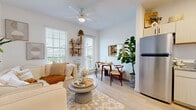 Located at 3845 Old Tampa Hwy in Lakeland, Florida, this two-story home offers four bedrooms and two full bathrooms across a thoughtfully designed floor plan. The main floor accommodates the open-concept living, dining, and kitchen area, while the upper floor houses additional bedrooms and a full bathroom connected by a hallway.

The living room is bright and welcoming, featuring light wood-style flooring, a ceiling fan, and large windows fitted with blinds that allow generous natural light. The space flows directly into a compact dining area, creating a cohesive and functional common area. The kitchen is efficiently laid out with light wood cabinetry, granite-style countertops, and a full suite of stainless steel appliances, including a refrigerator, range, and over-the-range microwave.

Each bedroom maintains a clean, light-filled aesthetic with windows offering exterior views. The primary bedroom features a calm, neutral palette. One secondary bedroom is notably versatile, comfortably accommodating bunk beds alongside a small activity area. Both bathrooms are consistent in design, each featuring a tub-shower combination with subway tile surround, a granite-top vanity, and light wood cabinetry. The overall ambiance throughout is modern, clean, and cohesive.