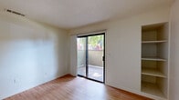 Located at 6430 Verner Avenue in Sacramento, California, this two-bedroom, two-bathroom residence offers a practical and well-organized single-level layout. The living area features light wood-style flooring and a large sliding glass door that invites abundant natural light and outdoor views, creating an open and airy atmosphere. The kitchen is efficiently designed in a U-shaped configuration, outfitted with crisp white cabinetry, ample counter space, a full suite of white appliances including a range, microwave, dishwasher, and refrigerator, all complemented by wood-style flooring that ties the space together. Both bedrooms are carpeted for comfort and feature vertical blinds over windows that frame views of the surrounding greenery. The primary bedroom includes a sliding-door closet, providing organized storage. The two full bathrooms are finished in a clean, neutral palette, each featuring a shower-tub combination, a white vanity with a mirrored cabinet, and wood-style flooring. A dedicated closet adds additional storage to the unit. The overall aesthetic is bright and understated, with neutral walls and consistent finishes throughout, offering a move-in-ready canvas in a convenient Sacramento location.