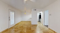This 1-bedroom, 1-bathroom single-floor unit offers a thoughtfully designed layout that maximizes its compact footprint. The main living area is immediately welcoming, showcasing warm travertine tile flooring that flows seamlessly throughout the space. Vaulted ceilings add a sense of openness and airiness, while a ceiling fan with integrated lighting and a pendant light fixture provide both function and style. A glass-paneled entry door invites natural light into the living area, which also features sliding glass doors dressed with vertical blinds.

The kitchen is efficiently laid out with dark wood cabinetry, granite countertops, and stainless steel appliances including a refrigerator and range. A pass-through counter with a built-in sink and a trio of vibrant amber pendant lights visually connects the kitchen to the living area, making it great for casual dining or entertaining.

The bedroom offers a comfortable and private retreat, featuring warm wood-look laminate flooring, a ceiling fan, and a window with exterior views that brings in natural light. An adjacent full bathroom is clean and functional, equipped with a tub-shower combination, tiled surround, and a vanity with granite countertop and dark wood cabinetry. The overall aesthetic throughout is bright, neutral, and move-in ready.