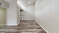 Located in Houston, TX 77090, this single-story residence showcases a consistent, modern aesthetic carried throughout by durable wood-look plank flooring in a warm gray-brown tone. Neutral-toned walls and white baseboards create a clean, cohesive look across all rooms.

The galley-style kitchen is outfitted with white shaker cabinetry, light countertops, a subway tile backsplash, an undermount sink with brushed nickel fixtures, and stainless steel appliances. High clerestory windows above the kitchen allow natural light to filter into the adjoining living area, which also benefits from vaulted ceiling height that enhances the sense of openness.

The bedrooms are well-proportioned, each featuring window blinds for light control and ceiling fans where applicable. A long hallway with textured walls connects the private sleeping areas to the rest of the home, providing a clear and functional layout.

Two full bathrooms include tub-shower combinations with white tile surrounds, standard fixtures in brushed nickel, and wood-look flooring that ties seamlessly to the rest of the home. One bathroom features a white vanity with storage. Throughout, the space maintains a clean, move-in-ready presentation with a practical, understated design.