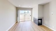 This contemporary 700 square foot apartment in West Hollywood offers a blend of style and functionality. The open concept living area seamlessly integrates the kitchen and living room, creating a spacious feel. The kitchen boasts modern amenities, including stainless steel appliances, granite countertops, and wooden cabinetry. A standout feature is the living room's fireplace, adding warmth and character to the space.

The bedroom, measuring 160 square feet, provides ample space and features a large mirrored closet. The apartment includes two well-appointed bathrooms, one likely en-suite to the bedroom. Throughout the space, light wood flooring adds a bright, airy feel, complemented by recessed lighting.

Large windows, including a sliding glass door leading to a balcony, flood the apartment with natural light and offer city views. The neutral color palette of whites and beiges creates a clean, modern aesthetic. Additional features include in-unit laundry facilities and central air conditioning, enhancing the comfort and convenience of this West Hollywood home.