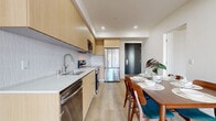 This contemporary 1220 square foot apartment, located at 7050 Hawthorn Ave Unit 501 in Los Angeles, offers a blend of comfort and style. The space boasts five bedrooms, including a generous primary bedroom of 570 square feet, and three bathrooms, all spread across a single floor. The open-concept living area features light wood flooring, white walls, and ample natural light, creating a bright and airy atmosphere. Large windows and sliding glass doors in the bedrooms and living room provide stunning city views and access to private balconies. The kitchen, though not visible in the images, likely maintains the modern aesthetic of the apartment. Bathrooms are sleek and minimalist, with glass-enclosed showers, light-colored tiles, and wooden vanities. Built-in closets in the bedrooms offer practical storage solutions. The apartment's decor is characterized by a neutral color palette with occasional pops of color through area rugs and plants, contributing to a contemporary and inviting living space in the heart of Los Angeles.