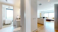 This single-floor high-rise residence is defined by its sweeping panoramic views, delivered through expansive floor-to-ceiling corner windows that frame broad city and treetop skylines from multiple rooms. The open-concept living and dining area maximizes these views, with the dining space positioned at the corner to capture sightlines in two directions. Light wood flooring runs throughout the main living areas, lending warmth to the bright, white-walled interior.

The kitchen is well-appointed with light grey shaker-style cabinetry, granite countertops, stainless steel appliances, a tile backsplash, and a peninsula with an undermount sink that opens toward the living space. The living room features generous proportions and large windows that flood the area with natural light.

Both bedrooms are carpeted and include large windows with outdoor views. The primary bedroom connects to a well-designed en-suite bathroom finished with large-format marble-look tile, a soaking tub, granite vanity, and a walk-in closet. A second bathroom, similarly finished with stone tile and a granite vanity, serves the additional bedroom. Throughout, the residence maintains a clean, contemporary aesthetic with consistent, high-quality finishes.