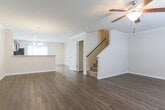 Located in Savannah, Georgia, this two-story home offers a thoughtfully designed layout that balances functionality and comfort across both levels. The main floor features generous open living and dining areas finished with warm hardwood-style flooring, crown molding, and ceiling fans that enhance the light, airy feel of the space. A chandelier adds a touch of elegance to the dining area, while large windows invite natural light throughout. The kitchen is well-equipped with rich cherry-toned cabinetry, light granite-style countertops, stainless steel appliances including a range, microwave, dishwasher, and refrigerator, along with a peninsula that provides additional prep and dining space. A convenient half bath with a pedestal sink and hardwood-style flooring is also located on the main level. The carpeted staircase leads to the upper floor, where bedrooms offer a quieter retreat. Bedrooms feature plush carpet, generous closet space with wire shelving systems, and access to a full bathroom complete with a tub-shower combination, rich wood vanity, and tile-style flooring. A spacious walk-in closet adds practical storage to the upper level. Throughout the home, clean white trim and neutral tones create a cohesive, move-in-ready atmosphere.