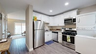 Located at 3501 Meadowdale Blvd in North Chesterfield, VA, this two-story, 2-bedroom, 2-bathroom home offers a thoughtfully organized layout spread across two floors. The main level features an open living room bathed in natural light from a large sliding glass door that leads to an outdoor area, creating a bright and welcoming atmosphere. The kitchen is well-equipped with white shaker-style cabinetry, granite-look countertops, stainless steel appliances including a gas range, dishwasher, and refrigerator, complemented by recessed lighting and durable wood-look flooring. A convenient in-unit stacked washer and dryer is also located on this level. A half-open layout connects the kitchen to the dining and living areas, enhancing the sense of space. A full bathroom is accessible on the main floor. Upstairs, the primary bedroom offers a comfortable retreat with plush carpeting, a ceiling fan, natural light from a window, and access to a dedicated closet and adjacent bathroom. The second bedroom, also carpeted and ceiling fan-equipped, features a bright window with outdoor views. Both bathrooms are clean and functional, with the full bath offering a tiled tub-shower combination. The warm, neutral color palette throughout creates a cohesive and inviting ambiance.