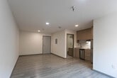 Located at 1831 Murchison Dr in El Paso, Texas, this single-floor unit offers a clean, modern aesthetic throughout with consistent light wood laminate flooring that creates a bright and cohesive feel across every room. The open main living area is finished with crisp white walls, recessed lighting, and a wall-mounted HVAC unit beneath a window that allows natural light to filter in. The space is thoughtfully laid out, providing a versatile area suitable for both living and sleeping arrangements, complemented by a walk-in closet for generous storage. The kitchen is a standout feature, outfitted with warm wood-tone cabinetry that extends to the ceiling for maximum storage, a white subway tile backsplash, a stainless steel refrigerator, a dishwasher, a cooktop with range hood, and a single-basin sink — all combining to create a functional and stylish culinary space. An additional open closet is conveniently accessible from the kitchen area. The entryway is clean and practical, featuring a solid door and an electrical panel panel neatly mounted on the wall. The bathroom is finished with marble-style tile flooring and includes a full tub and shower combination enclosed by a sliding frameless glass door with brushed nickel hardware, lending a contemporary, spa-like quality to the space.