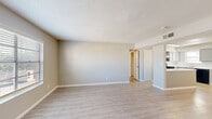 Located at 5120 Kodiak Ave in El Paso, Texas, this single-story, three-bedroom, three-bathroom home offers a well-organized layout with a clean, neutral aesthetic throughout. Light wood-style flooring runs continuously across the living areas and bedrooms, complemented by soft beige and grey wall tones that create a bright, cohesive atmosphere. Textured ceilings are present throughout the home.

The welcoming entrance opens to a spacious living room featuring large windows fitted with horizontal blinds that allow for ample natural light. The kitchen stands out with grey cabinetry, white subway tile backsplash, white countertops, and black appliances including a gas range, refrigerator, and dishwasher, along with a window above the sink that adds natural light to the cooking space.

The three bedrooms are well-sized, with the primary bedroom offering generous proportions, dedicated closet space, and an en-suite bathroom. Each bedroom benefits from natural light via windows. The three bathrooms are cleanly finished, with at least one featuring a glass-enclosed shower. Dedicated closets serve each bedroom, providing practical storage throughout. Two hallways connect the rooms efficiently, contributing to a functional and comfortable single-floor floor plan.