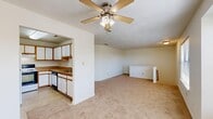 Located at 372 N College Dr in Franklin, Virginia, this single-floor, 3-bedroom, 2-bathroom home offers a practical and comfortable layout. The open living area is spacious and bright, featuring warm neutral carpet, a ceiling fan with light fixture, and multiple windows that invite natural light and views of the surrounding neighborhood. The kitchen is thoughtfully appointed with white cabinetry trimmed in warm wood tones, laminate countertops, tile flooring, and a full suite of appliances including a refrigerator, electric range, and dishwasher. A staircase element adds architectural interest to the living space. The primary bedroom is well-sized, carpeted, and equipped with a ceiling fan and multiple windows that provide ample natural light and outdoor views. The additional bedrooms are similarly carpeted with clean white walls and good natural light. Both bathrooms are finished in a clean, functional style — one features a tub/shower combo with a large mirror and vanity, while the other includes a wood-trimmed vanity with a wide mirror. Throughout the home, the consistent use of neutral tones and carpet creates a cohesive, understated ambiance well-suited for comfortable everyday living.